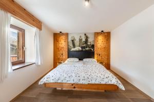 1 dormitorio con 1 cama y una pintura en la pared en Naturoase Stegerhof Apt Iris, en Trodena
