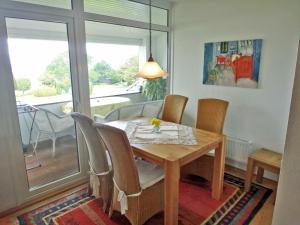 a dining room with a wooden table and chairs at Fischreiher 2 in Kappeln