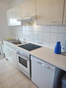 a white kitchen with a sink and a stove at Fischreiher 2 in Kappeln