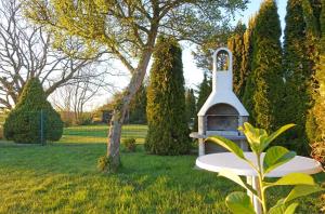 a bird house sitting in the grass next to a tree at Fischreiher 2 in Kappeln