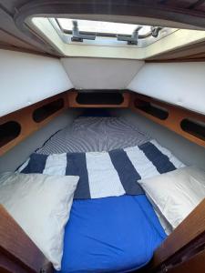 ein Bett auf der Rückseite eines Bootes mit zwei Kissen in der Unterkunft El Velero in Puerto Calero