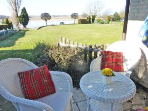 a table and chairs on a patio with a view of a field at Möwe in Kappeln