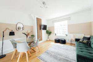 a living room with a green couch and a table at Stylish Central Kings Cross 2 Bedroom Flat in London