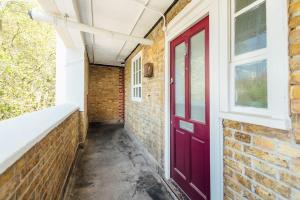 a red door on the side of a brick building at Stylish Central Kings Cross 2 Bedroom Flat in London