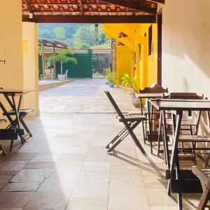 a patio with tables and chairs in a building at Pousada Sunflower in Pirenópolis