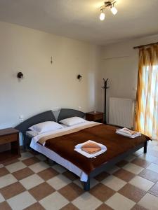 a bedroom with a large bed with two towels on it at Nikos's apartment in Taxiarchis