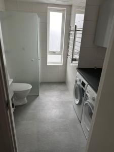 a bathroom with a washing machine and a window at Ny lgh i Varberg, 80 kvm, 4 rum in Varberg