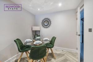 uma sala de jantar com uma mesa e cadeiras verdes em HUGE 5 Bed 3 Bath House For Contractors & Families, X2 FREE PARKING, FREE WiFi & Netflix By REDWOOD STAYS em Farnborough