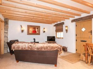 - une chambre avec un grand lit et un plafond en bois dans l'établissement Bull Bach Old Smithy, à Pwllheli