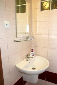bagno con lavandino bianco e specchio di Guest House Vila Pod Lesom a Bystrá