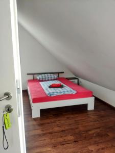 a small bed in a attic with a red mattress at das Apartmenthaus in Freiburg in Freiburg im Breisgau