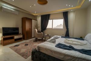 Habitación de hotel con cama y TV en Gardenia Apartment Pyramids View en El Cairo
