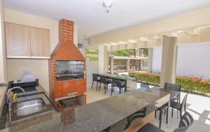 uma cozinha com um forno de tijolos no meio de uma sala em Residencial João e Maria - Aptos 03 quartos em Porto Seguro