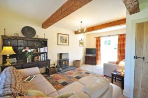 a living room with a couch and a fireplace at Old Mill Cottage in Kelso