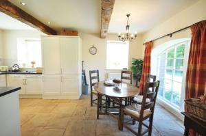 a kitchen with a wooden table and chairs in a room at Old Mill Cottage in Kelso