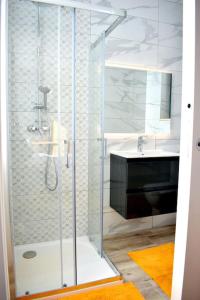 een glazen douche in een badkamer met een wastafel bij Seaside Serenity Retreat in St Paul's Bay