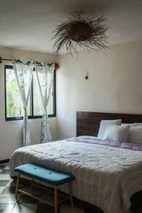 1 dormitorio con 1 cama grande y un taburete azul en Casa Mate BeachFront HOUSES El Cuyo en El Cuyo