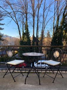 dwa krzesła i stół oraz dwa stoły i krzesła w obiekcie ElegantLiving Graz, free parking w Grazu