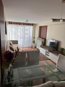 sala de estar con sofá y mesa en Comodo y acogedor depa en Lince, en Lima