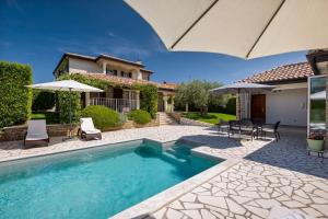a swimming pool in front of a house at Rustic villa Inga with pool and grill in Buje in Kaštel