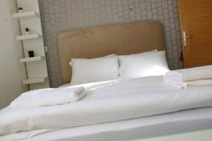 a bed with white sheets and pillows on it at Belle maison avec jardin privatif in Casablanca