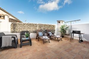 a patio with chairs and a table and a piano at Sunset Cas Sastre in Alcudia