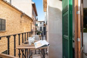 a table on a balcony with a book and mugs at Sunset Cas Sastre in Alcudia