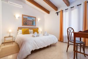 a bedroom with a large bed with a desk and a table at Sunset Cas Sastre in Alcudia