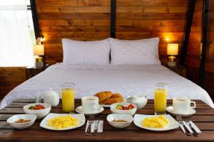 - un plateau de produits pour le petit-déjeuner sur un lit dans l'établissement Glamping Guaytambos Lodge, à Patate