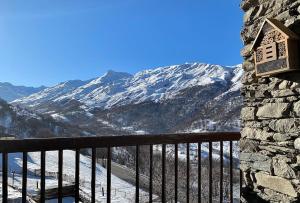 a balcony with a view of a snow covered mountain at Spacieux Chalet Authentique dans les 3 Vallées in Saint-Marcel