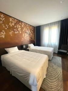 a hotel room with two beds and a tree mural at Fuwa Fuwa Home - Wyndham Lynn Times Thanh Thủy- Khu nghỉ dưỡng Khoáng nóng in Phú Thọ