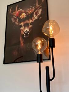 two lights on a wall with a picture of a deer at gemütliches Dachgeschoss in Bonn