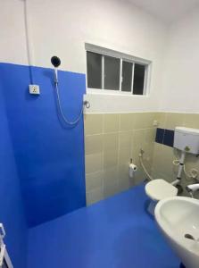 - une salle de bains bleue avec 2 toilettes et un lavabo dans l'établissement Pearl Villa Rooms and Hostel, à Unawatuna