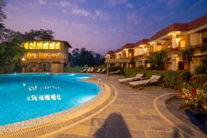 a swimming pool in front of a building at Hotel Jungle Crown in Sauraha