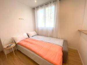a small bed in a room with a window at Appart Laffitte joli T2 au coeur du parc & parking & RER pour Paris & La Défense in Maisons-Laffitte
