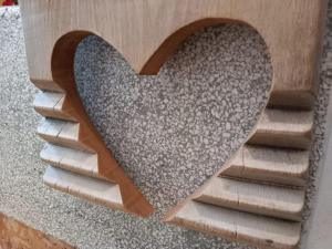 un corazón de madera en el lateral de un edificio en La casa di Donna Anna, en Squinzano