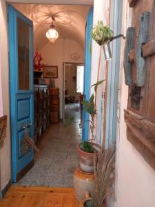 un pasillo con una puerta azul y una maceta en La casa di Donna Anna, en Squinzano