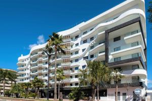 a white building with palm trees in front of it at Selecta Estepona Roof Top Pool 3 in Estepona