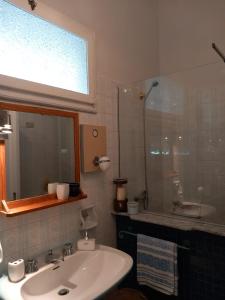 ein Bad mit einem Waschbecken und einer Glasdusche in der Unterkunft La casa di Donna Anna in Squinzano