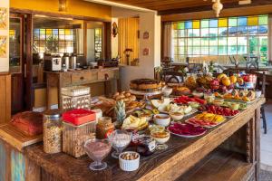 een buffet met veel verschillende soorten eten op tafel bij Pousada Serra Villena in Monte Verde
