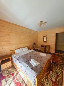 a bedroom with a large bed in a wooden room at Готель Ярсон in Yaremche