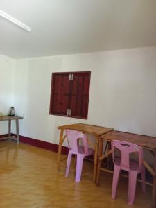 uma mesa e duas cadeiras cor-de-rosa num quarto em Som PalmGarden em Ko Lanta