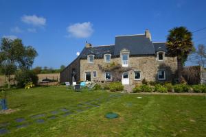 a large stone house with a green yard at La petite salmonais in Saint Malo