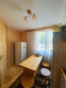 a kitchen with a wooden table and a refrigerator at Готель Ярсон in Yaremche