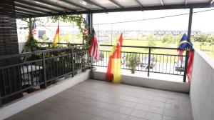 balcón con banderas y vistas a la ciudad en Kita Bayu Townhouse, en Kampung Dengkil