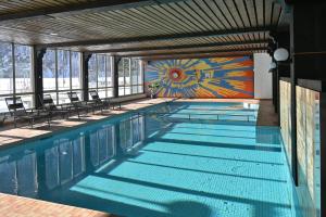 a swimming pool with chairs and a mural on the wall at Cosy 3.5 pièce à Täsch in Täsch