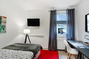 Schlafzimmer mit einem Bett, einem Schreibtisch und einem Fenster in der Unterkunft Lotsenbude in Wilhelmshaven
