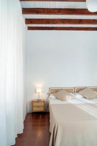 1 Schlafzimmer mit 2 Betten und weißen Vorhängen in der Unterkunft La Casa del Convento in Villamanrique de la Condesa