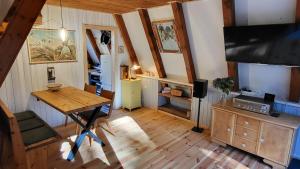 uma sala de estar com uma mesa de madeira e uma televisão em Finnhütte zwischen Wald und See em Biesenthal