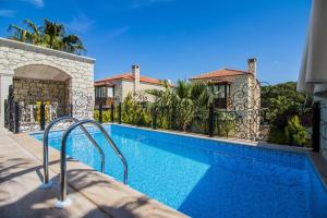 a swimming pool in front of a house at Fedora Otel Alaçatı in Alaçatı